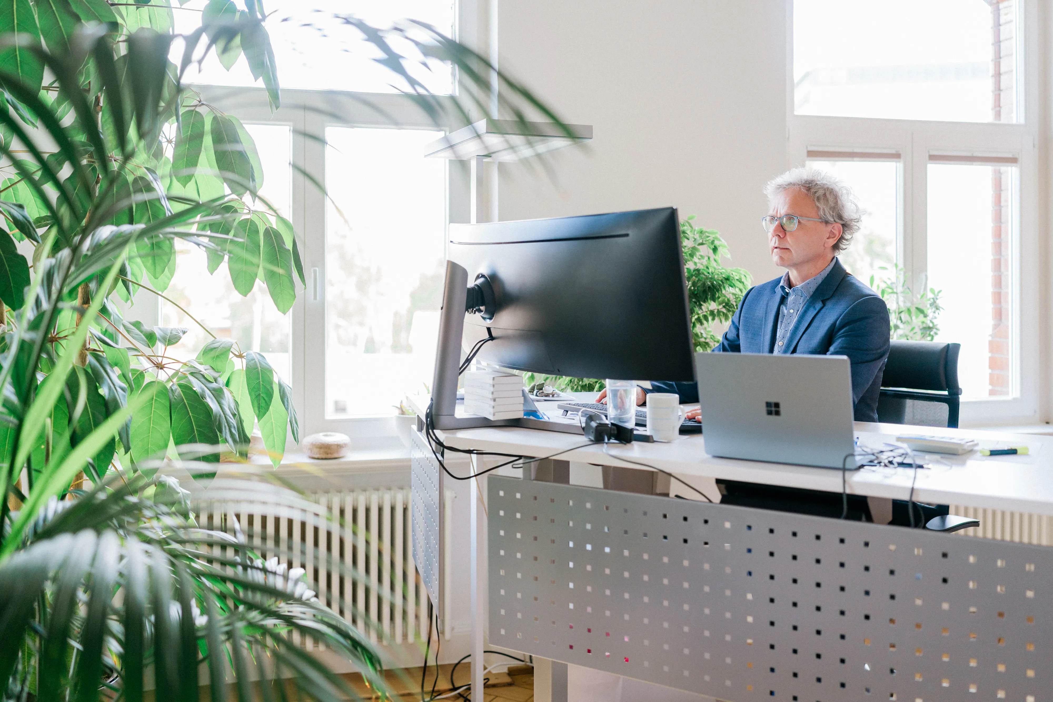 Ein Mitarbeiter von FRP.tax arbeitet konzentriert an seinem Schreibtisch mit Laptop und externem Monitor.