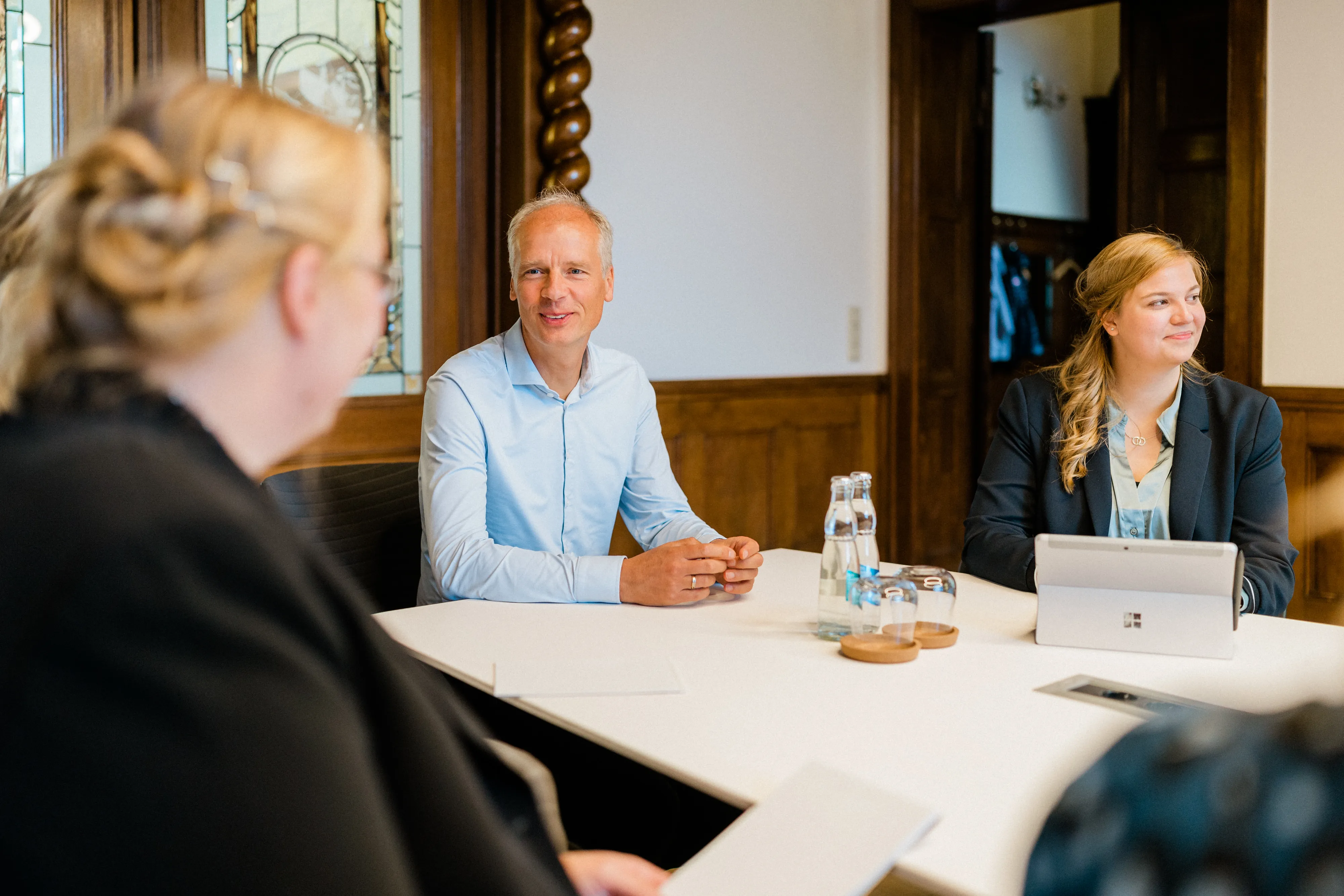 Drei Mitarbeiter von FRP.tax in einem Besprechungsraum, die sich im Bereich der klassischen Steuerberatung austauschen.