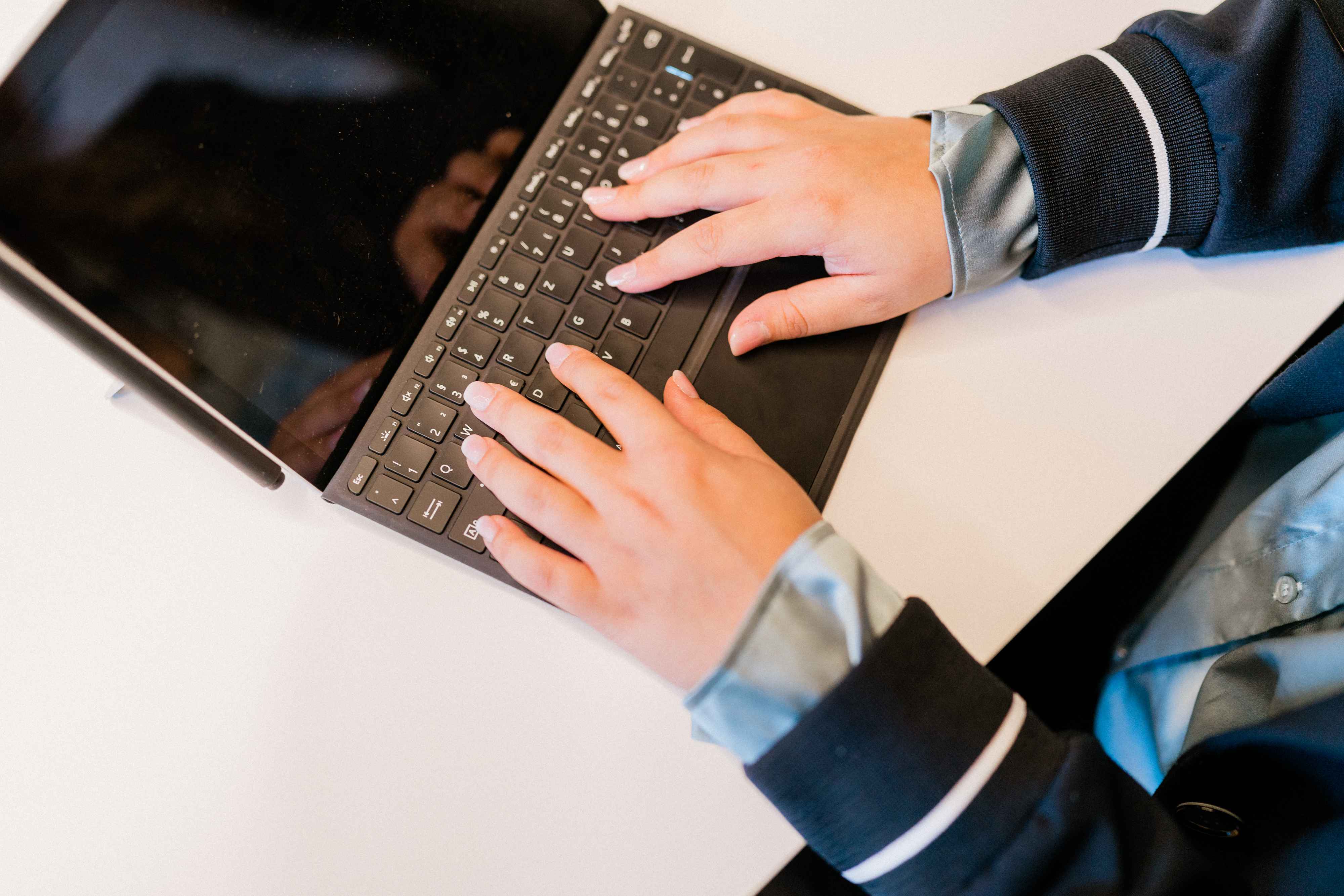 Hände tippen auf einem Laptop, das flexible Arbeitsmodelle wie Home-Office oder Gleitzeit bei FRP.tax darstellt.