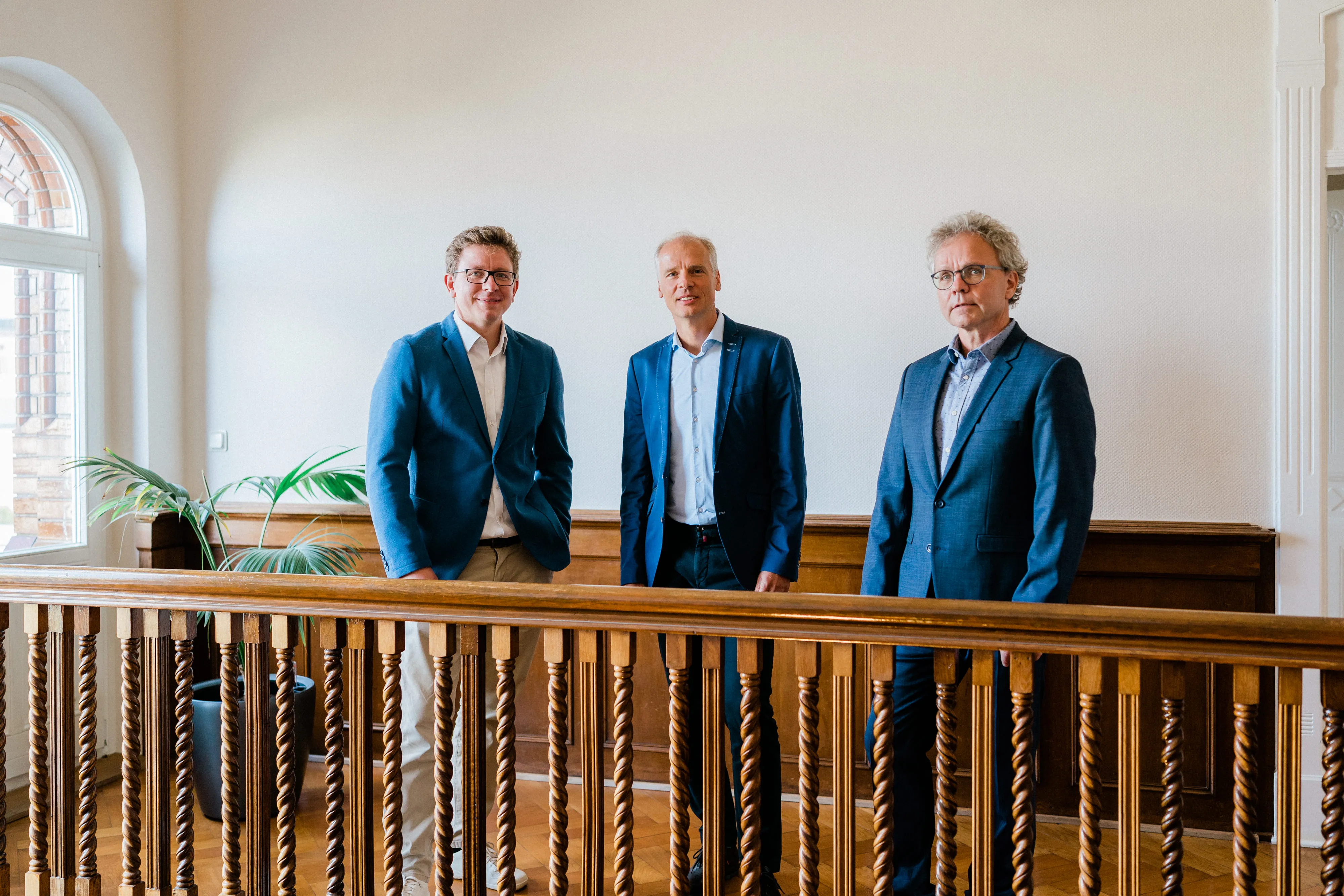 Drei Partner von FRP.tax blicken selbstbewusst in die Kamera, symbolisierend die persönliche und leidenschaftliche Beratung des Unternehmens.
